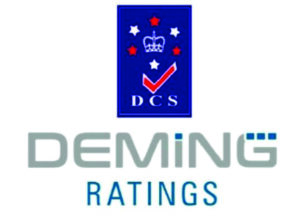 Logo of Deming Ratings featuring a vertical dark blue rectangle with a white crown, red and white stars, a red checkmark, and the text "DCS" written in white, with the company name "DEMING RATINGS" printed below in grey and blue text.