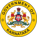 Circular emblem of the Government of Karnataka featuring a yellow border with black text, enclosing the state coat of arms with two mythical Sharabha figures flanking a shield with a two-headed eagle, topped by the State Emblem of India.